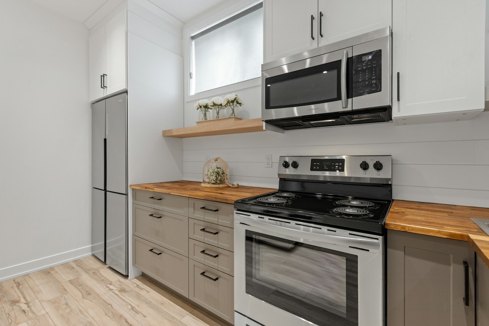 Modern kitchen featuring sleek stainless steel appliances, a wooden countertop, and minimalistic cabinetry. Ideal for contemporary living spaces.