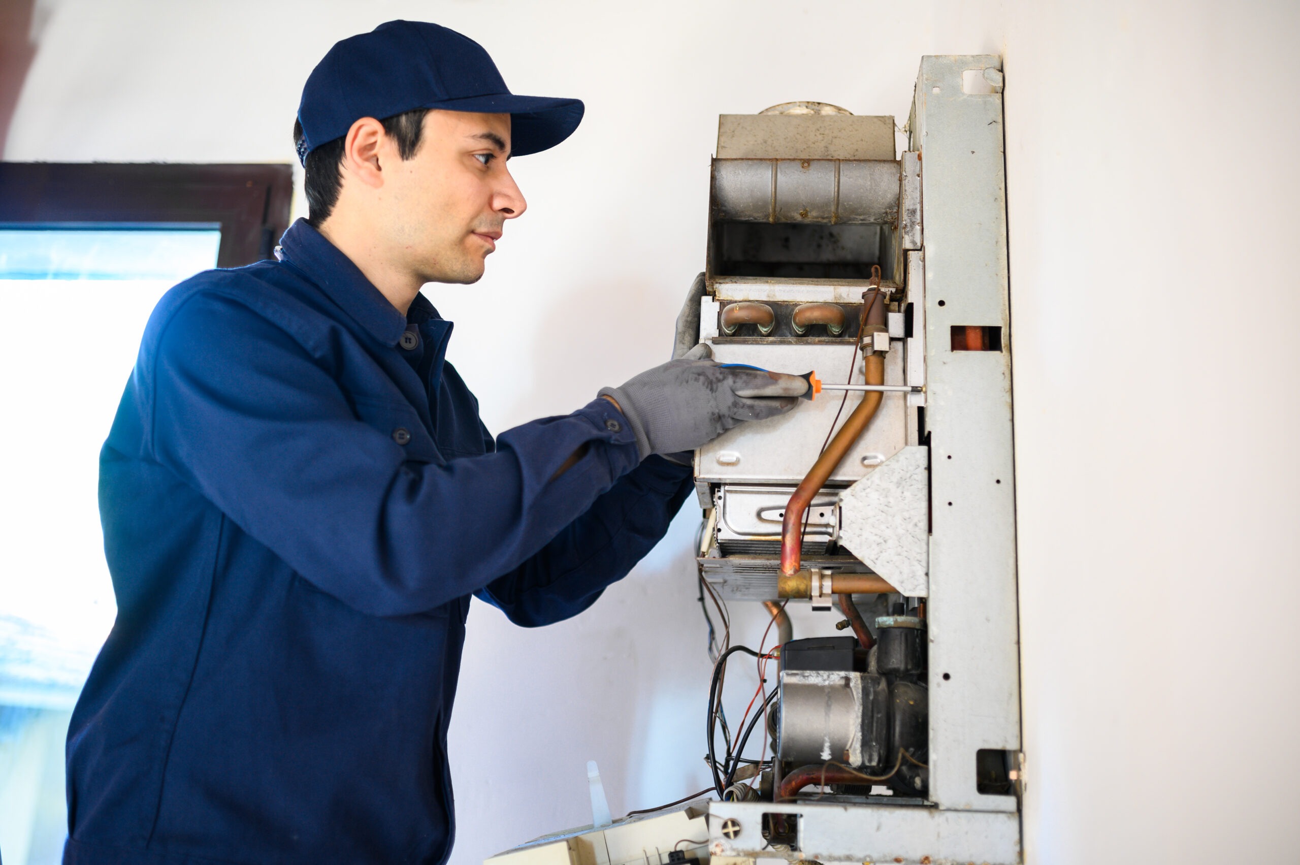 Smiling technician repairing an hot-water heater
